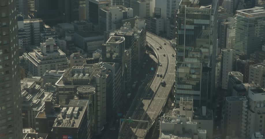 A six lane highway runs through a city with a mix of skyscrapers