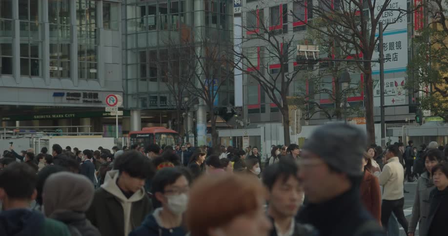A large group of people are walking through a downtown city