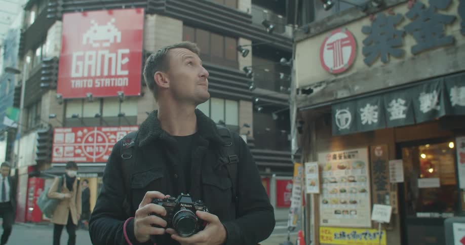 Man taking photograph in down town area of an asian country