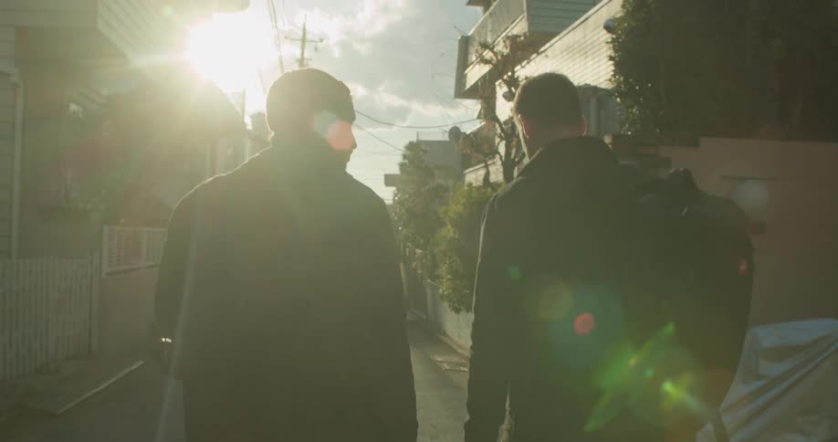 Two friends walk down the street in the neighborhood
