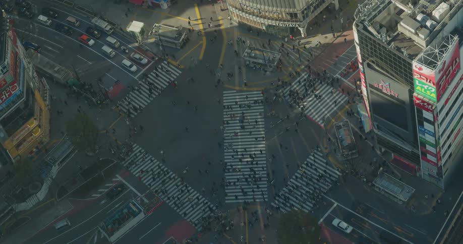 People crossing a busy intersection in a city