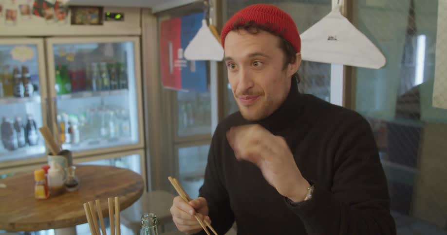 Two men sit in a restaurant and eat