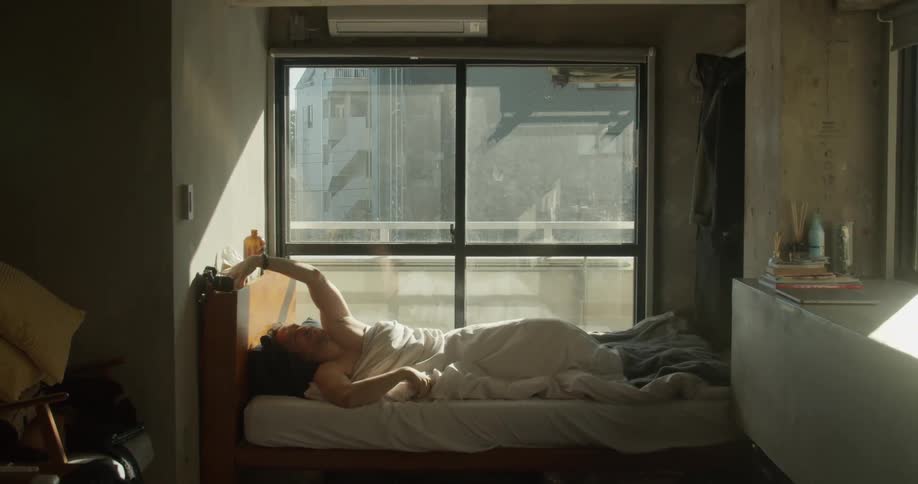 Man waking up in early morning and reaching for cell phone