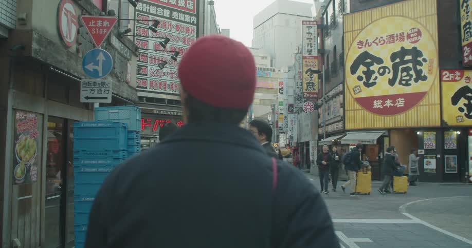 A white male walks through the downtown area of an asian city