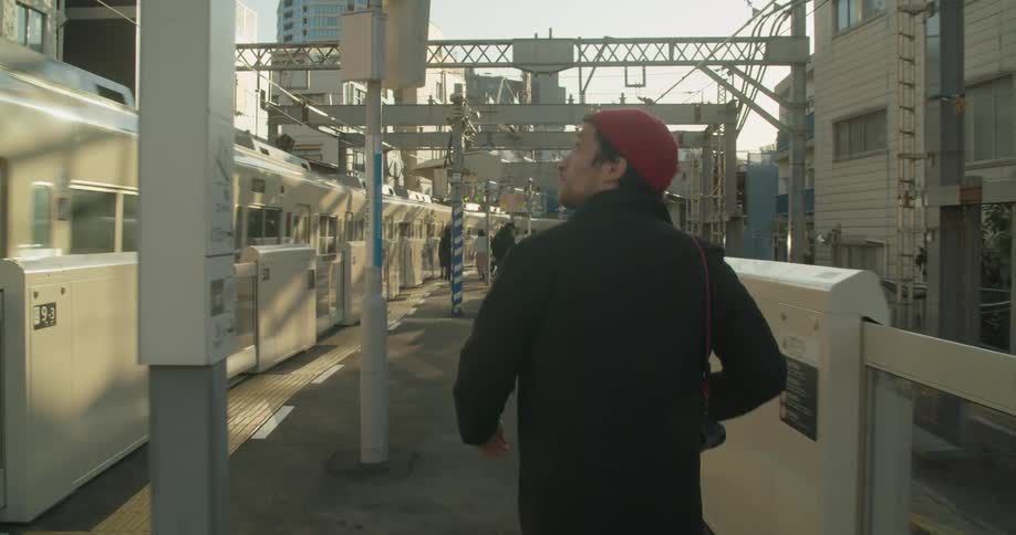 A white male walks through a train station area