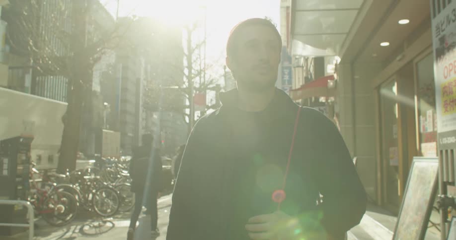 A man is walking down the busy sidewalk in the city
