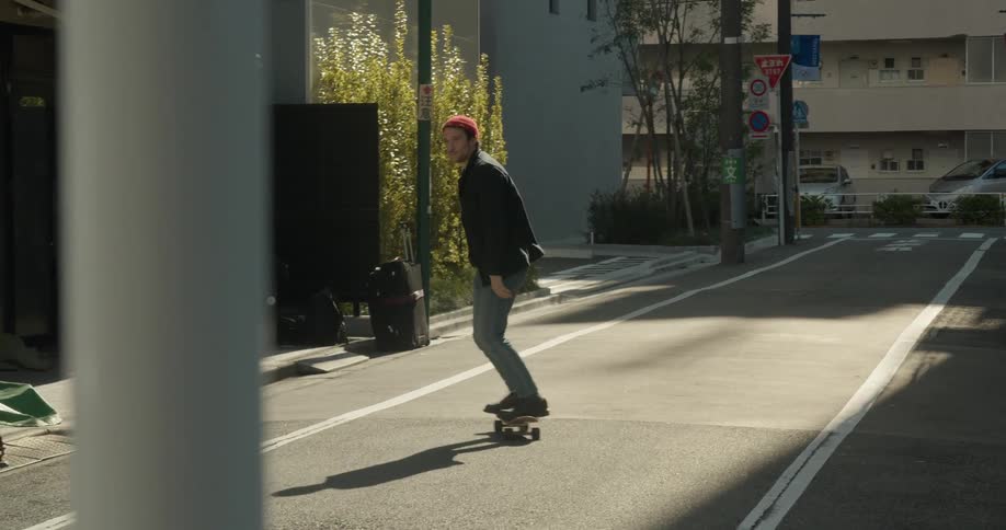 A man skateboards down a city alley