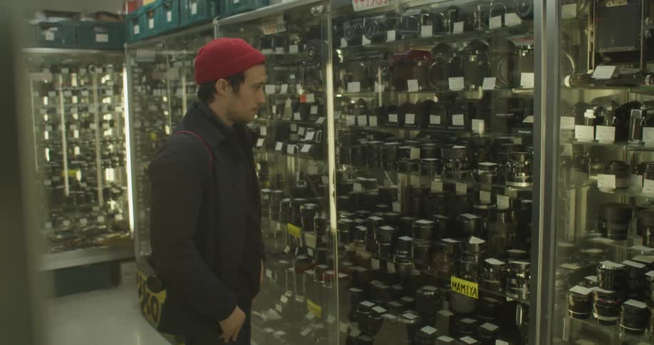 A man looks inside a glass door of items inside a store