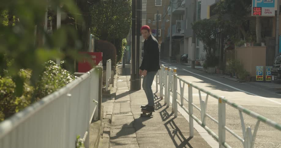 A man skateboards down a city street