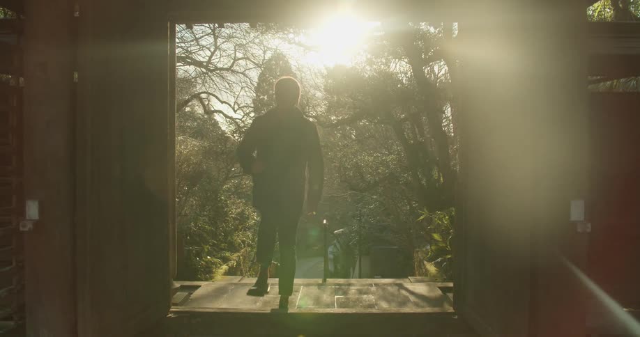 A man hikes up the stairs near the forest