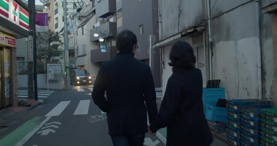 Couple holding hands walks in the narrow street