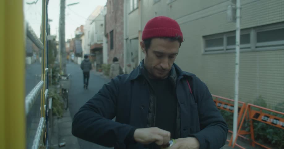 The man grabs a drink out of the vehicle