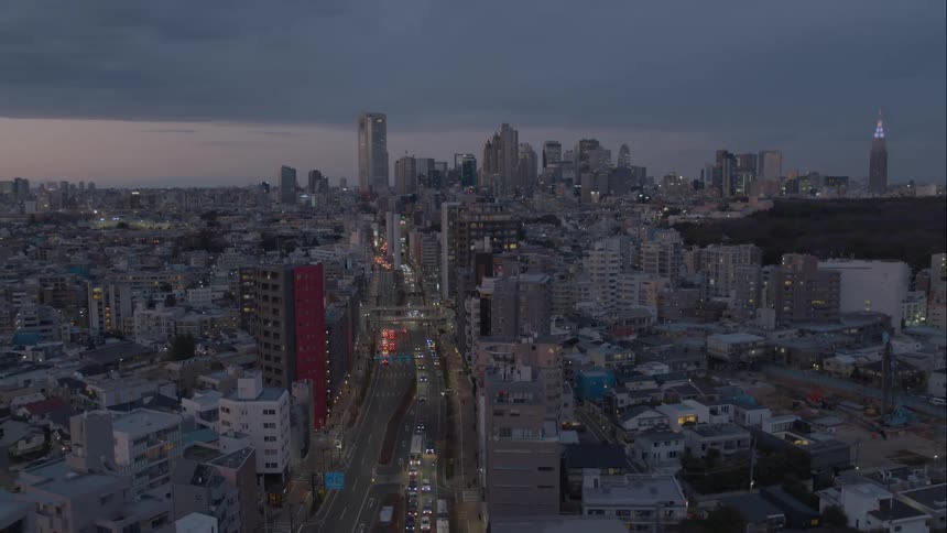 Traffic moves down a road stretching out from a large city downtown