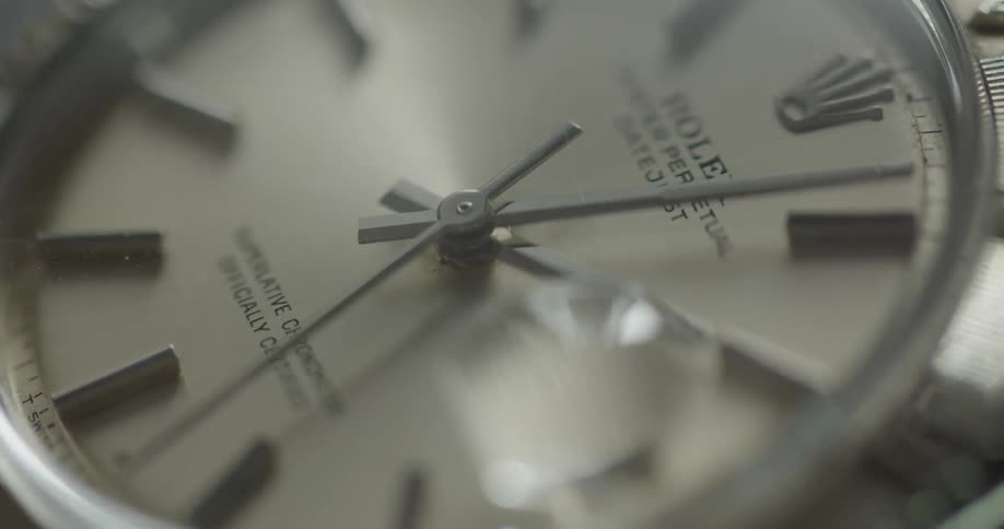 Watch hands move around face on wristwatch