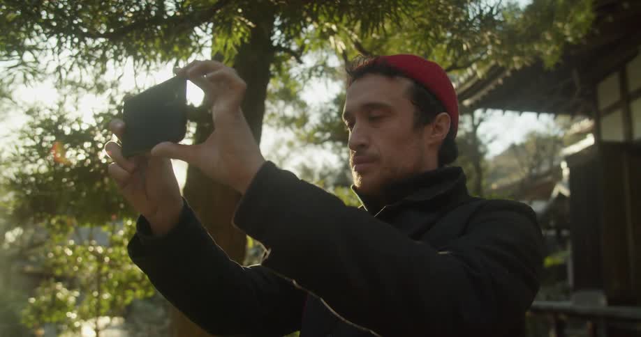 A man takes a picture with his smarthouse outside of a house