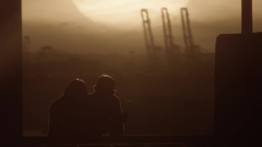 A silhouette of a man and woman talking with the sunset in the background