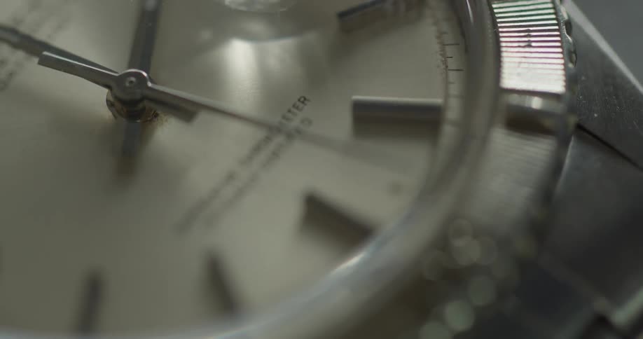 Close up of second hand rotating around the dial on a wristwatch