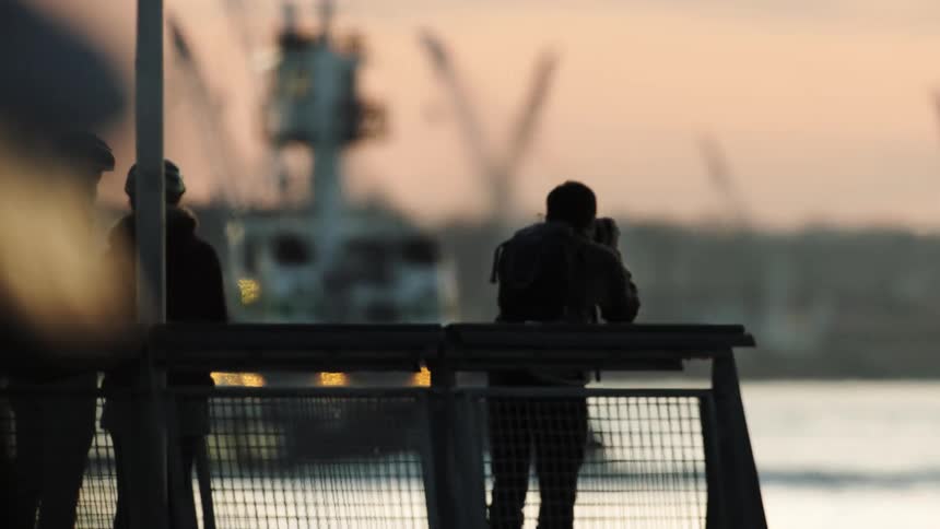 Silhouette of Tourist Photographing Passing Boat