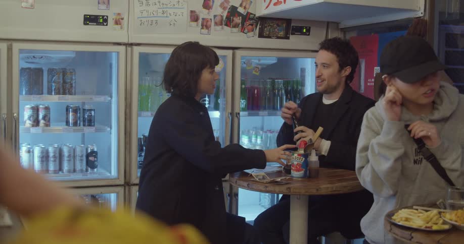 A white and woman sit at a table in a restaurant and get ready to order a meal