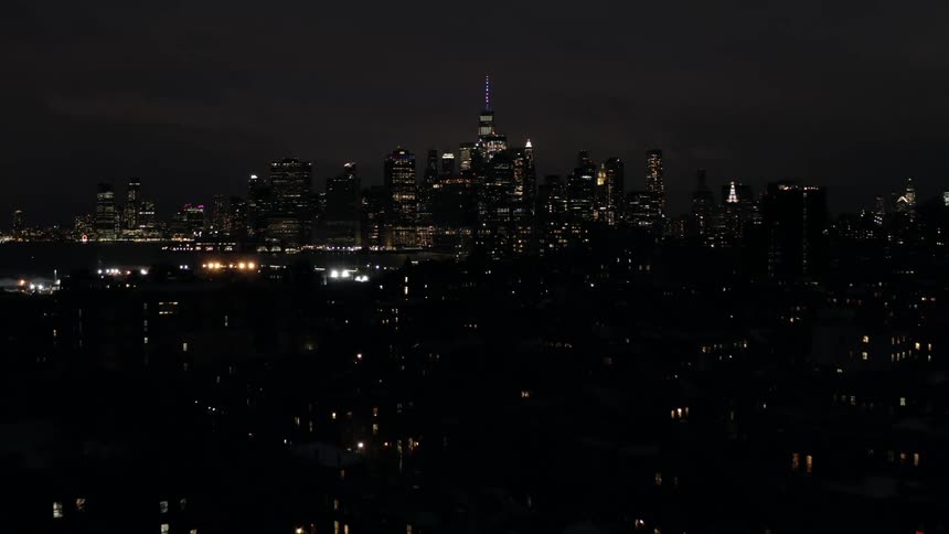 An aerial view of a downtown skyline is displayed at night