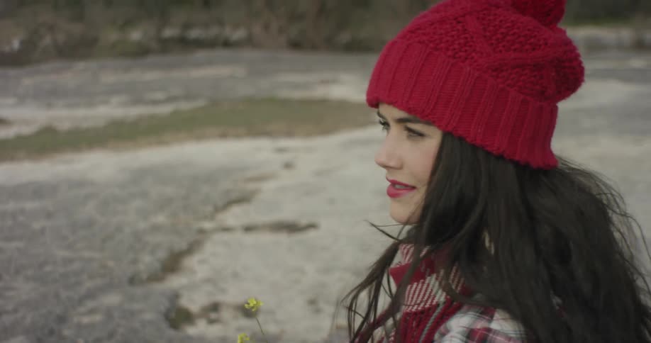 A woman in a red hat looks around