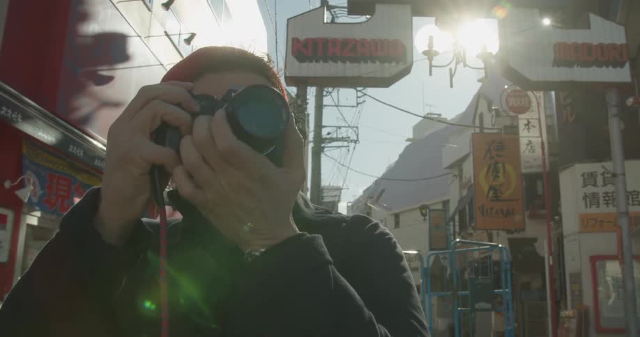 A man turns to take a photograph in the city