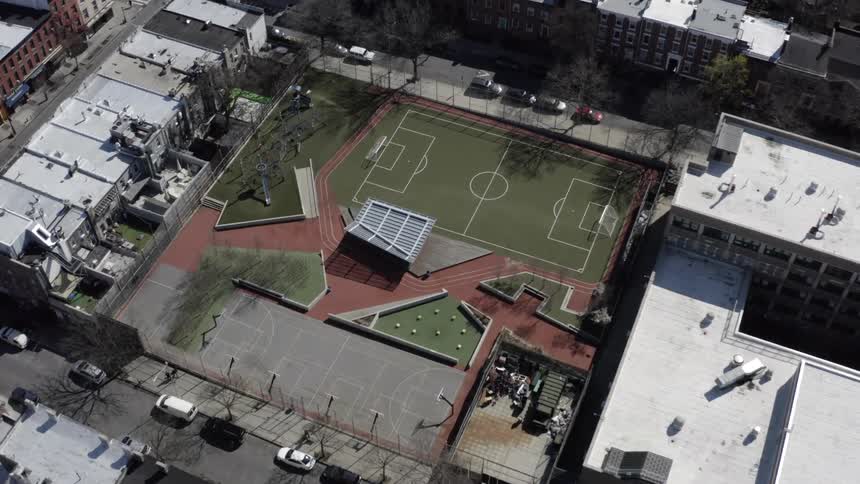 An aerial view of a downtown city and field is displayed
