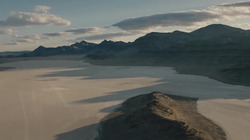 Mountains loom over a desert terrain