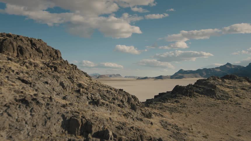 A desert with mountains in the background