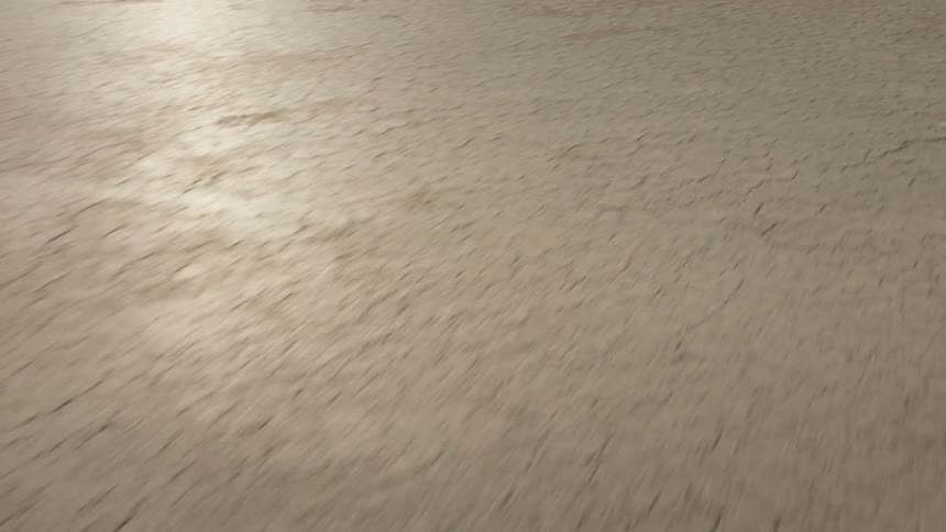 A flat desert lies in front of some large hills