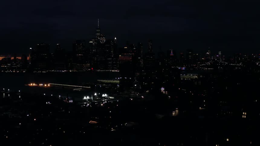 A downtown area of a city twinkles with light at night