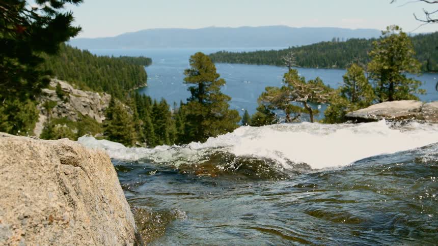 A river flowing with a lake and trees in the background