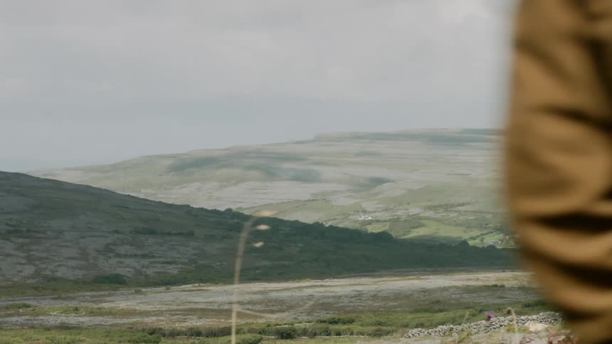 A person briefly walks past the hills
