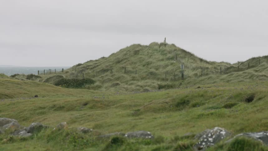 View of the green hills and distant sea on a cloudy day