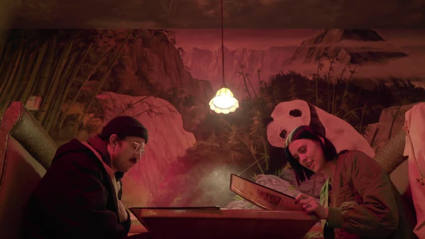 Couple sitting at the table looks at the menu in the dimly lit restaurant