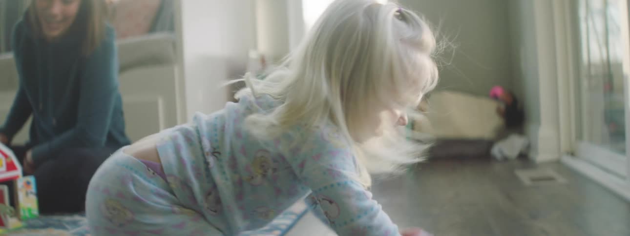 A child rocks across the living room floor