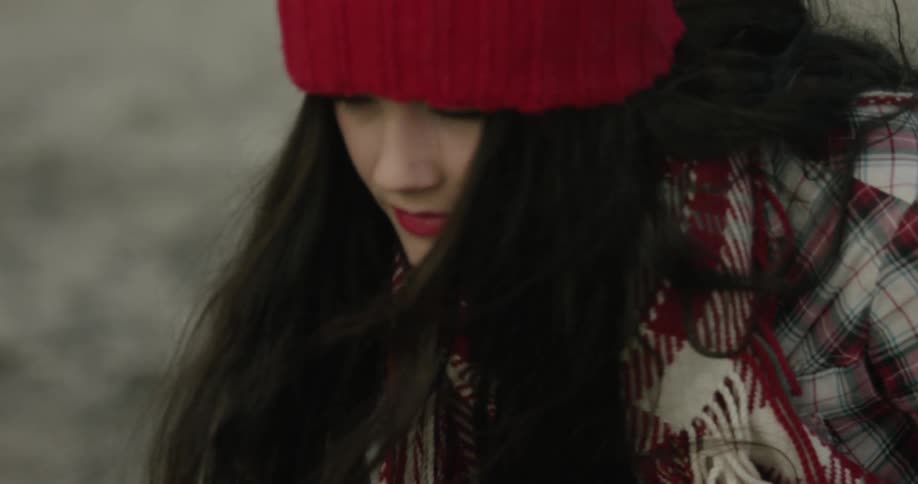 A woman wrapped in a blanket slowly stands up