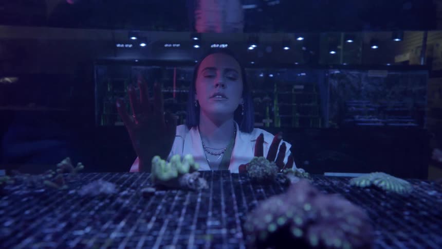 Woman touches the fish tank and closes her eyes in ecstasy
