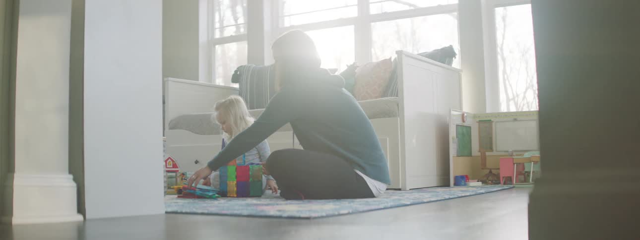Mother and daughter play together in the living room at home
