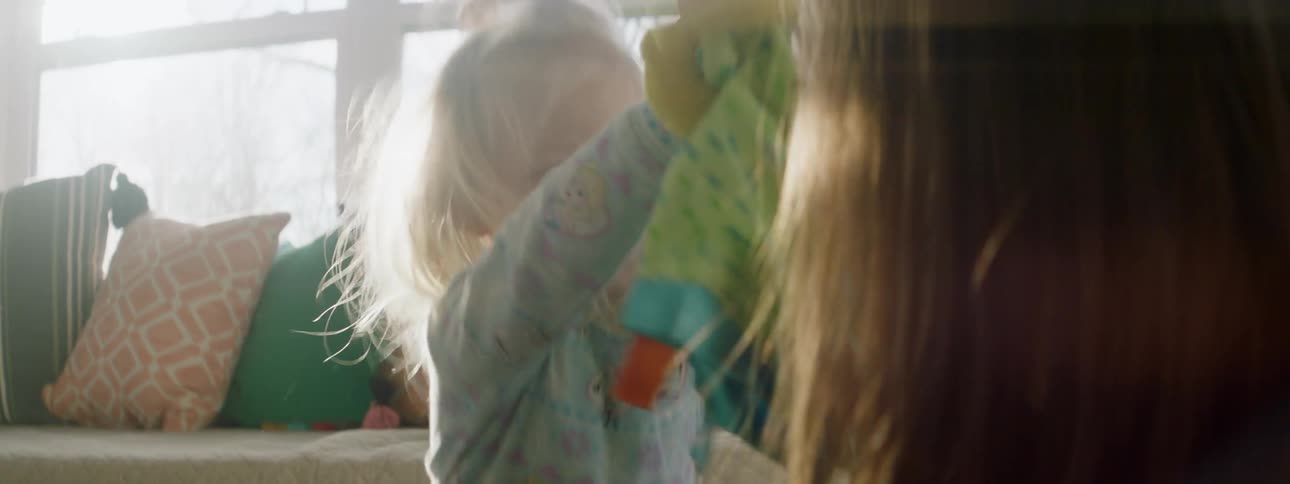 A mother and daughter are playing indoors