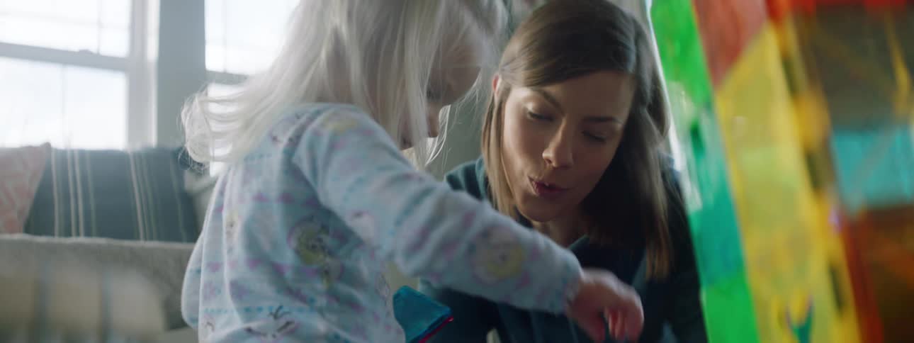 Mother and daughter play together in the living room