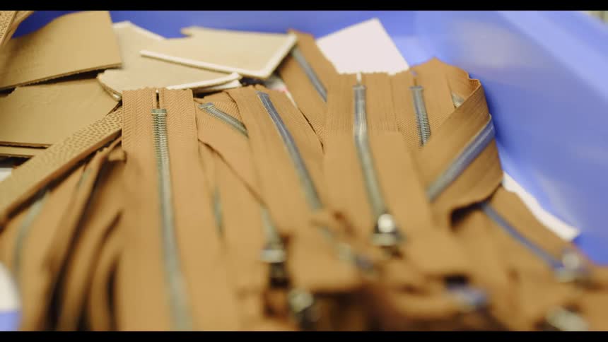 A factory with a bin filled with zippers