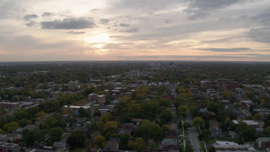 A neighborhood full of houses at dusk on a cloudy evening