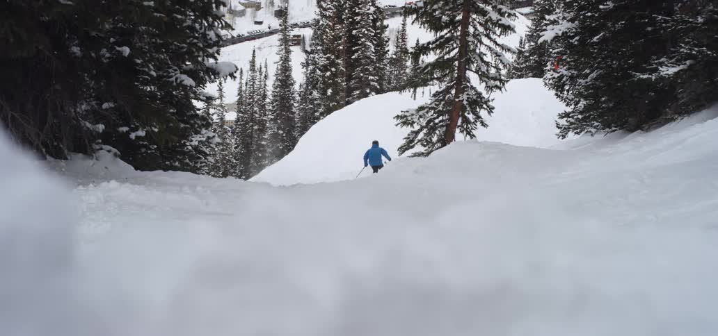 A skier moves down a slope covered in snow