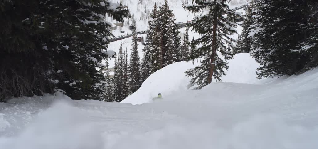 A skier goes down a snow slope and jumps on their skis