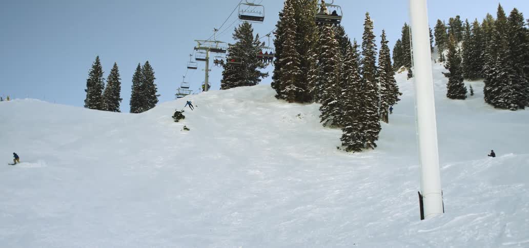 Skiers jumping skiing and riding the chair lift at a ski resort