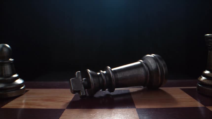 A knocked over chess piece on a board
