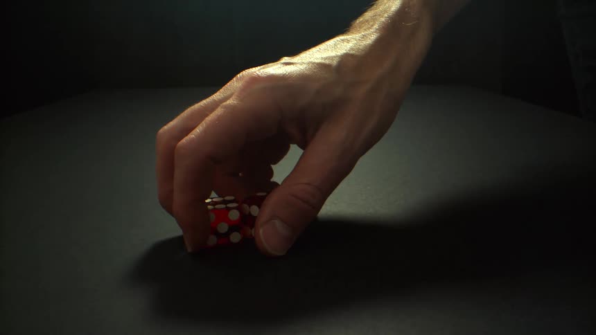 A person picks up the dice