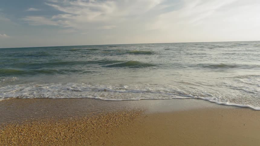Ocean waves crash upon a sandy beach