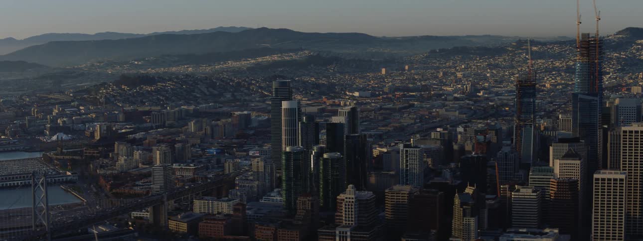 A large urban area sits in front of a distant mountain range